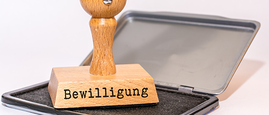 Symbolbild: Ein Stempel mit der Aufschrift „Bewilligung“ liegt auf einem Stempelkissen.