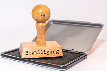 Symbolbild: Ein Stempel mit der Aufschrift „Bewilligung“ liegt auf einem Stempelkissen.
