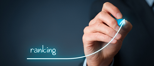 Foto:Hand mit Stift zeichnet einen Pfeil nach oben. Daneben steht das Wort „Ranking“