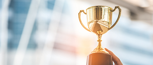 Bildbeschreibung: Ein Pokal wird von vier Händen in die Luft gehoben.