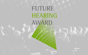 Bildbeschreibung: Auf dem Schwarz-Weiß-Foto ist schemenhaft sitzendes Publikum abgebildet, das den Blick nach vorne richtet. Darüber ist das Logo der Veranstaltung abgedruckt: der Schriftzug Future Hearing Award und ein grafisch dargestelltes Echo. Das Wort Hearing und das Echo sind im Phonak-Grün gedruckt, die Wörter Future und Award in einem Dunkelgrau.
