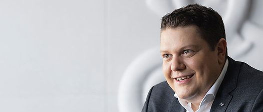 Bildbeschreibung: Auf dem Foto ist Neuroth CEO Lukas Schinko zu sehen. Er gestikuliert und erklärt einem Gesprächspartner einen Sachverhalt. Letzterer ist im Bild allerdings nicht zu sehen.