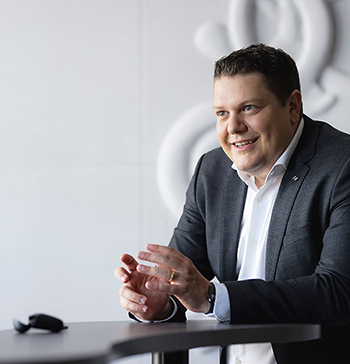 Bildbeschreibung: Auf dem Foto ist Neuroth CEO Lukas Schinko zu sehen. Er gestikuliert und erklärt einem Gesprächspartner einen Sachverhalt. Letzterer ist im Bild allerdings nicht zu sehen.