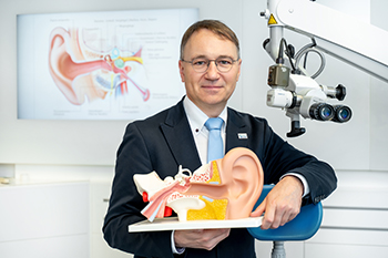 Das Foto zeigt Professor Dr. Stefan Plontke, Direktor der Universitätsklinik und Poliklinik für Hals-Nasen-Ohren-Heilkunde, Kopf- und Halschirurgie der Universitätsmedizin Halle, mit einem Ohrmodell.